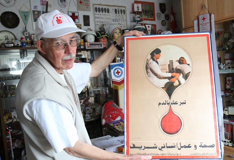 Dietrich Holle mit einem Blutspendeplakat aus dem Irak