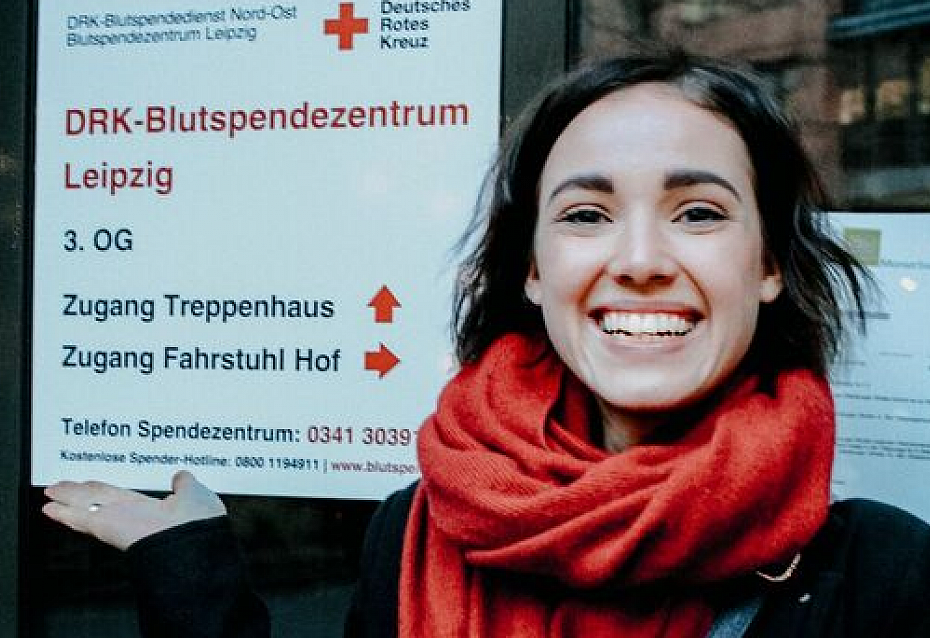 Frau mit Immunthrombozytopenie steht vor dem DRK Blutspendezentrum Leipzig