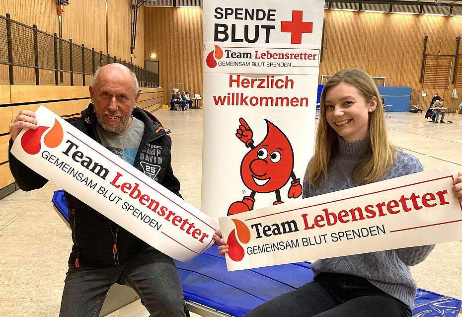 Blutspender sitzen auf Liege halten Plakat Team Lebensretter