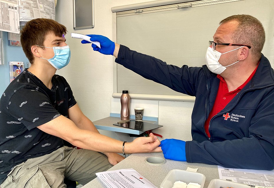 Blutspender Tobias Philipp bei der Bestimmung der Körpertemperatur vor der Spende im DRK-Blutspendemobil