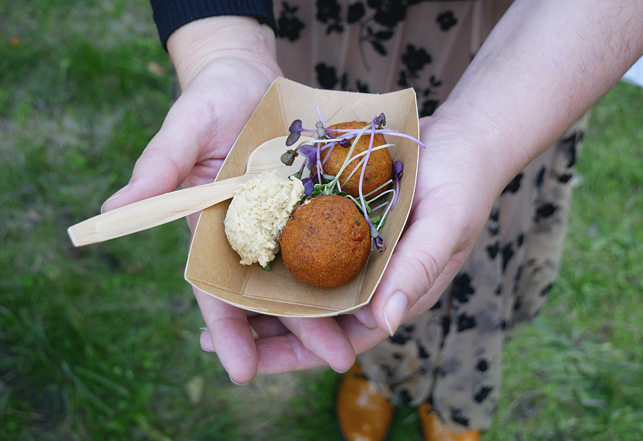 Eine Hand hält eine Schale mit Falafeln