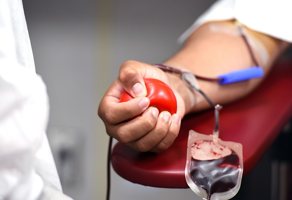 Ein Blutspender erhöht durch das Pumpen des roten Balls den Blutfluss bei der Entnahme