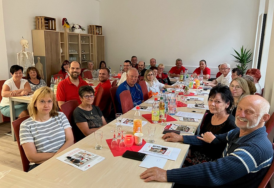 Ehrenamtliche Helferinnen und Helfer sitzen gemeinsam am Tisch im Rahmen der Heferschulung in Lößnitz 