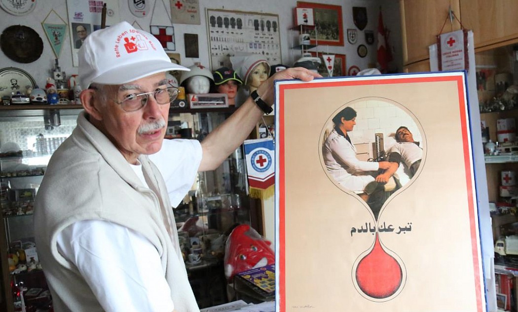 Dietrich Holle mit einem Blutspendeplakat aus dem Irak