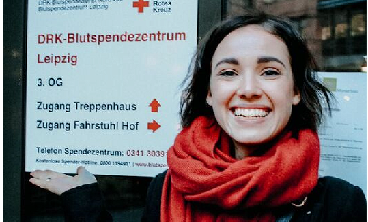 Frau mit Immunthrombozytopenie steht vor dem DRK Blutspendezentrum Leipzig