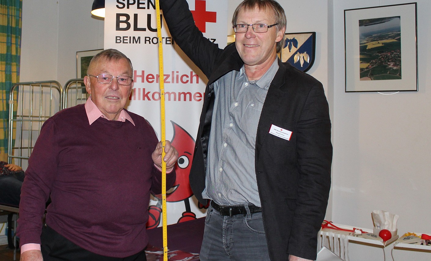 Hans Michaelis und Harald Hinz vom DRK-Blutspendedienst verdeutlichen anhand eines Zollstocks, wie viel 196 Blutspenden sind