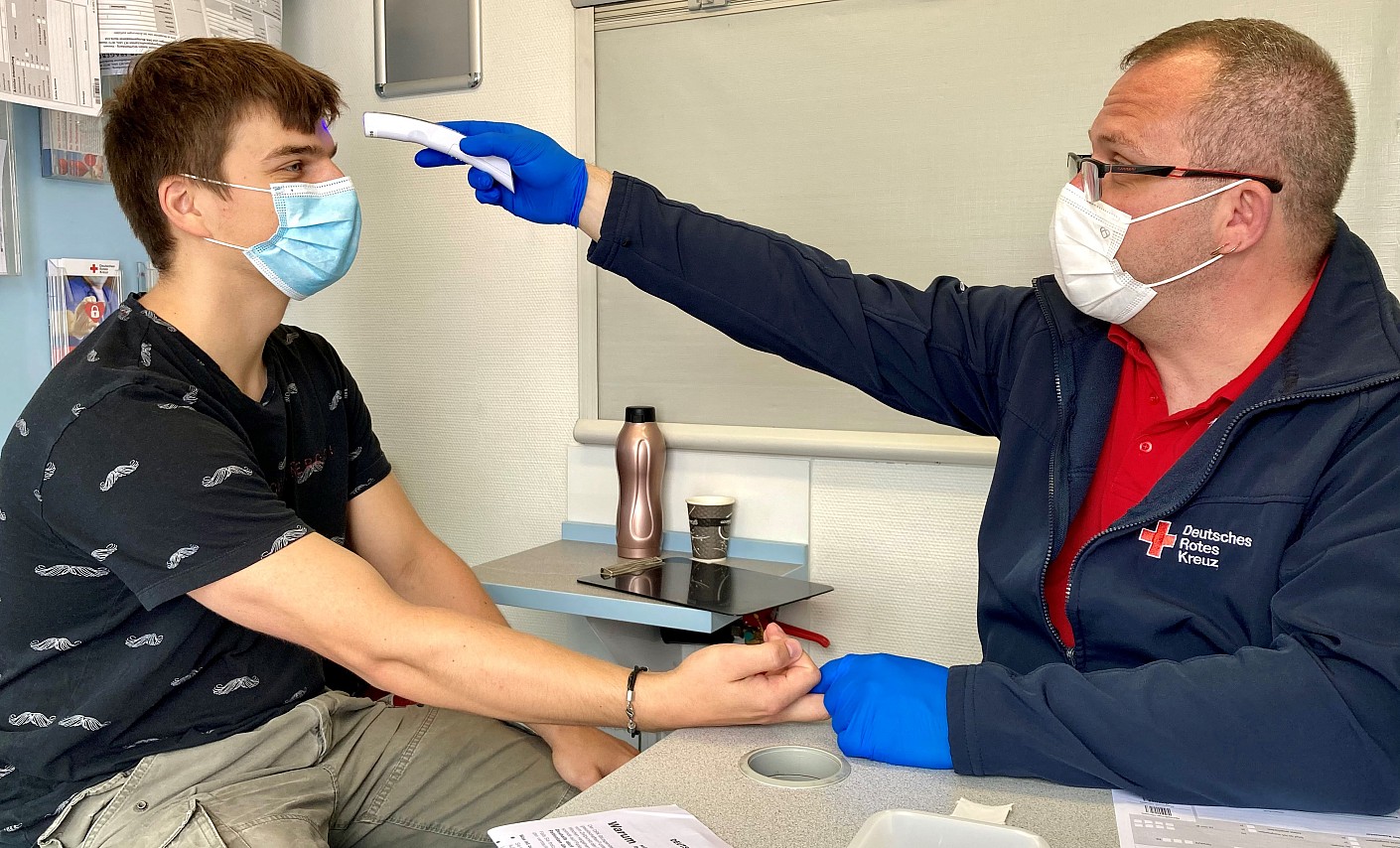 Blutspender Tobias Philipp bei der Bestimmung der Körpertemperatur vor der Spende im DRK-Blutspendemobil
