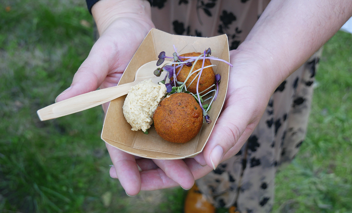 Eine Hand hält eine Schale mit Falafeln