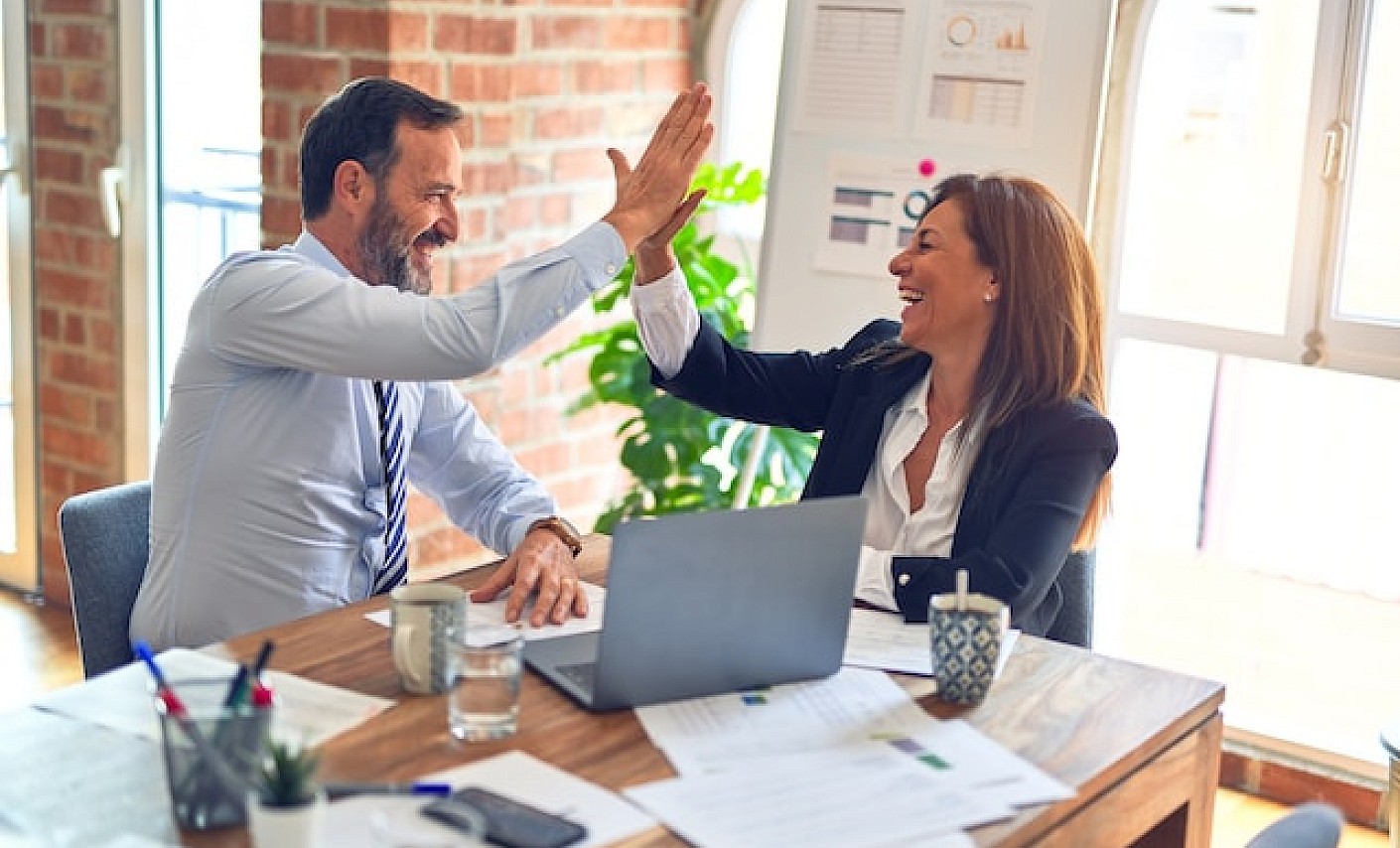 Mann und Frau im Business Kontext geben sich ein high-five