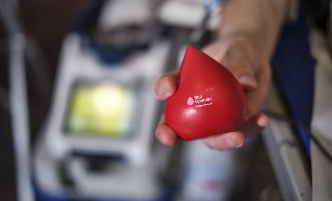 Blutspende für den Warm Glow Effekt Hand eines Blutspenders knetet Schaumstoff-Tropfen zur Hilfe bei der Blutspende