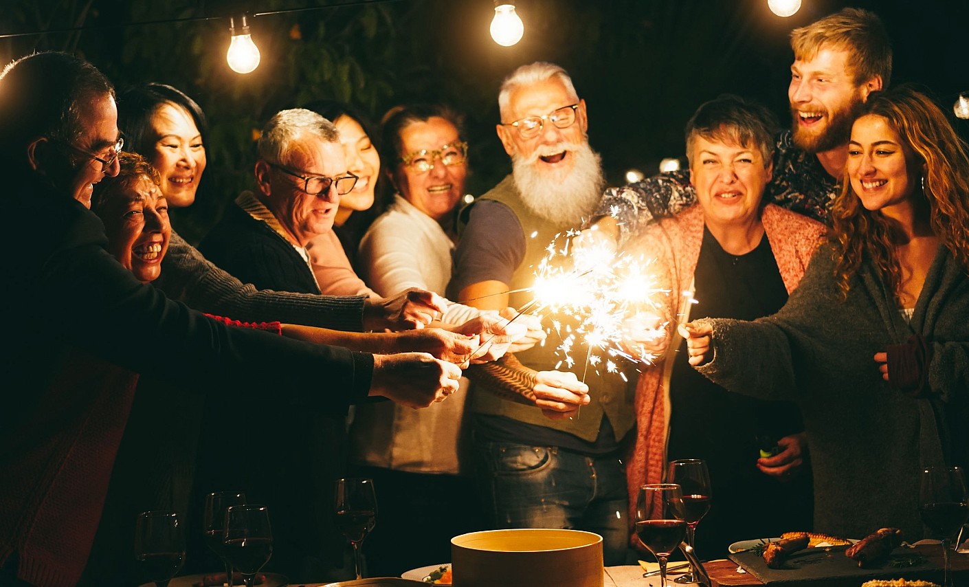 Gemeinsam mit Freunden macht alles mehr Spaß Familie und Freunde entzünden bei einer Feier gemeinsam Wunderkerzen