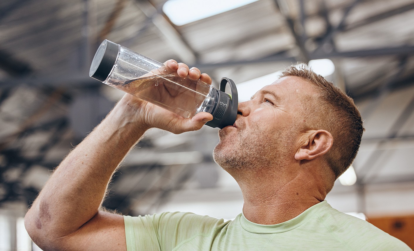 Wasser trinken ist wichtig! Mann trinkt Wasser aus Flasche