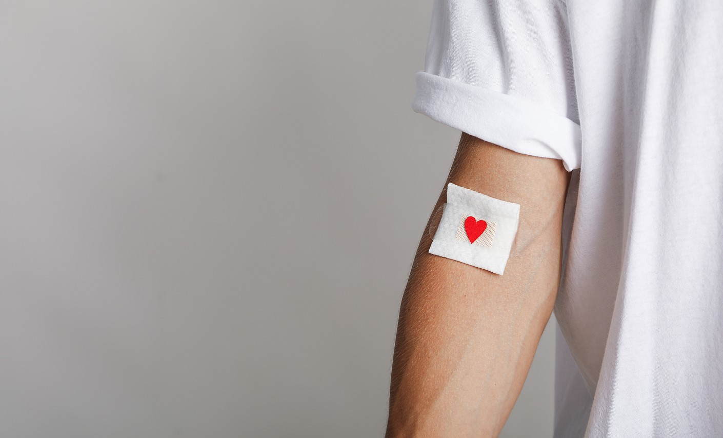 Blutspender im weißen T-Shirt mit Herz auf Plaster