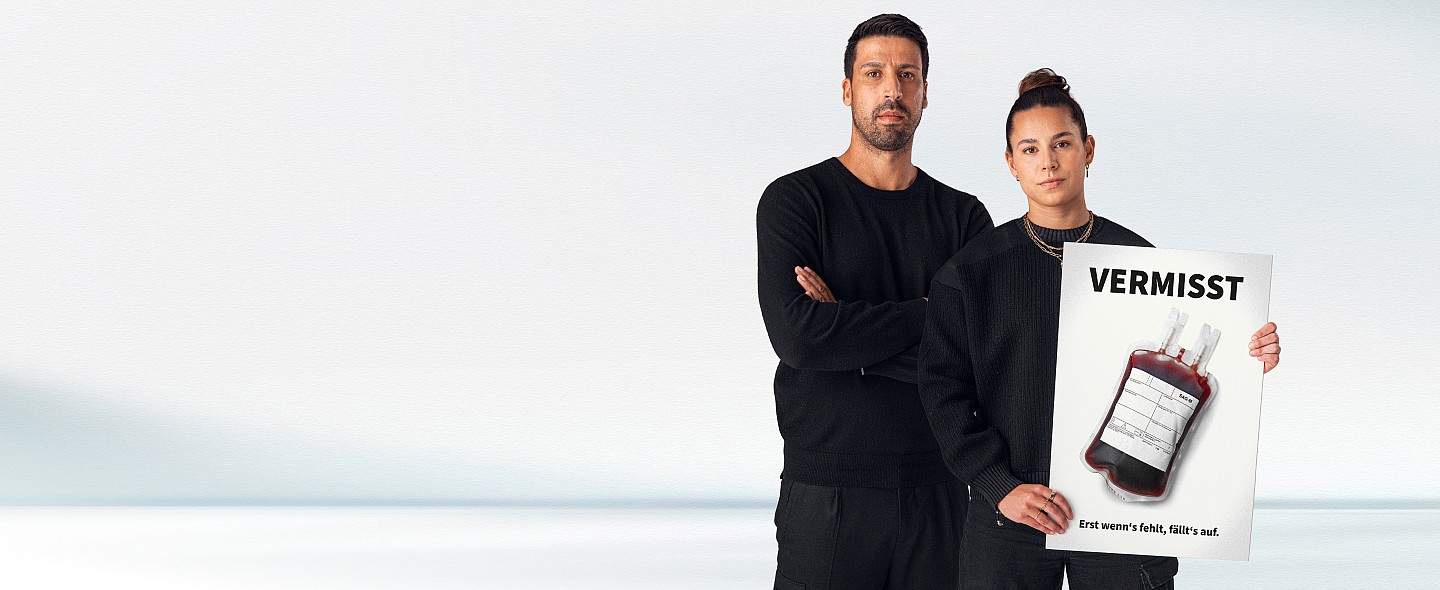 Zwei Personen stehen im Bild vor einer weißen Wand: Sami Khedira und Lena Oberdorf, Lena halt ein Plakat mit einem Blutbeutel und der Aufschrift: Vermisst! Erst wenns fehlt, fällts auf. 