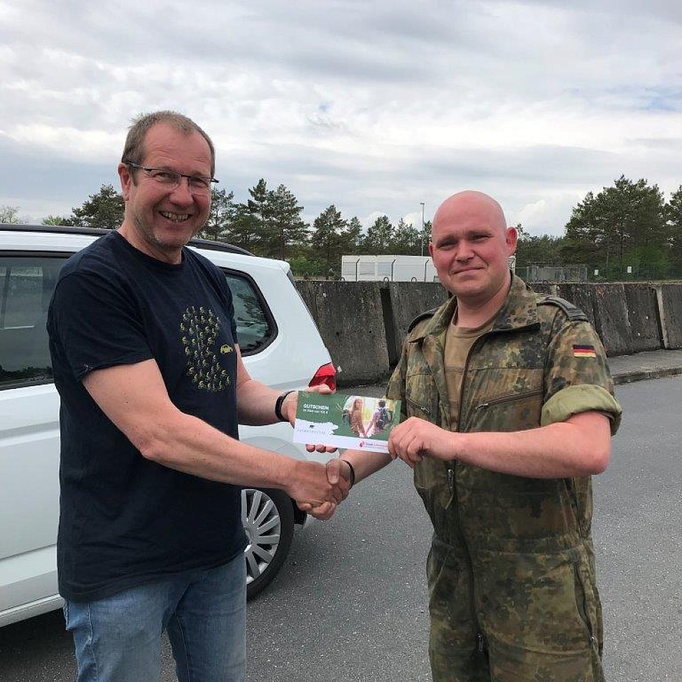 Gewinner Sven Zander (rechts) erhält seinen Gutschein aus den Händen von Norbert Nowakowski von unserem Blutspendedienst in der Kaserne Holzdorf in Brandenburg