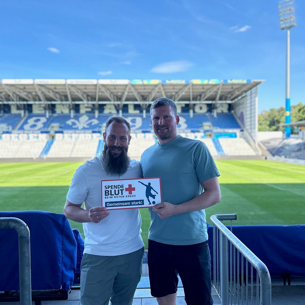 Spielder des SV Darmstadt 98 halten das Spende Blut Schild hoch